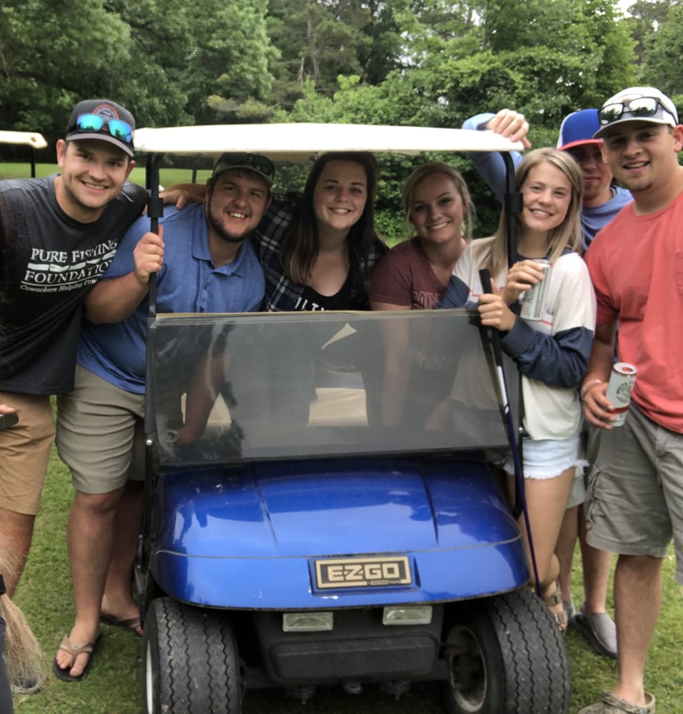Group of friends posing on golf cart